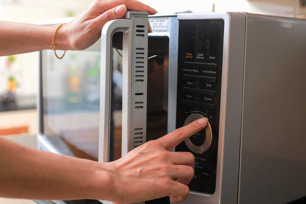 Woman's Hands Closing Microwave Oven Doo